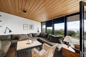 a living room with a couch and a table at Architect Designed Holiday Home With Sea View in Gudhjem