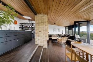 a kitchen and living room with a brick fireplace at Architect Designed Holiday Home With Sea View in Gudhjem