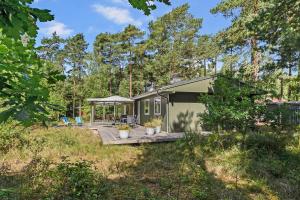 a tiny house in the woods with a patio at Cottage In Peaceful Surroundings In Vester Sømark in Vester Sømarken +14 photos