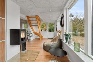 a living room with a television and a staircase at Modern House With Space For Relaxation in Åkirkeby