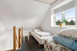 a bedroom with a bed and a window at Modern House With Space For Relaxation in Åkirkeby