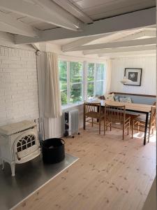 a living room with a table and a stove at Cozy And Modernized Fishing Cabin in Hornslet