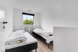 two beds in a room with a window at Amazing Holiday Home With View At The Water in Vig