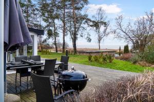 a grill on a patio with a table and chairs at Amazing Holiday Home With View At The Water in Vig