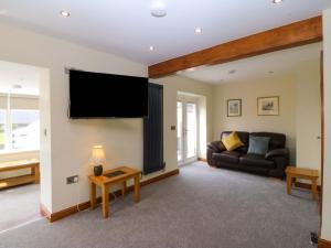 a living room with a couch and a flat screen tv at Dalar Deg in Rhiw