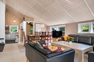 a living room with a couch and a table at Summer House In Beautiful Nature In Brunshuse in Hårby