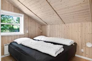 a bedroom with two pillows on top of a bed at Summer House In Beautiful Nature In Brunshuse in Hårby