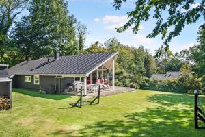 a small house with a porch and a yard at Summer House In Beautiful Nature In Brunshuse in Hårby
