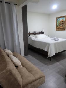 a living room with a bed and a couch at BED & Breakfast in Bogotá
