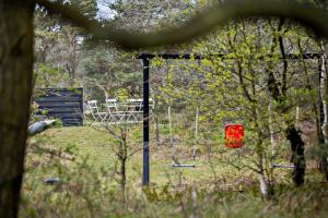 a swing set in a park with a playground at Holiday Apartment In Peaceful Surroundings in Neksø +5 photos