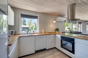 a kitchen with white cabinets and a sink at Holiday Home With Outdoor Jacuzzi And Shelter in Vig