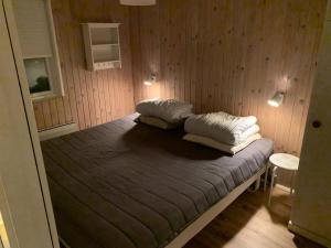 ein Bett in einem Zimmer mit zwei Kissen darauf in der Unterkunft Ruhig Gelegenes Ferienhaus In Meeresnähe in Brenderup