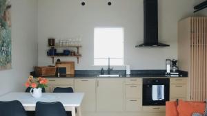 a kitchen with white cabinets and a table and a window at Rural Cottage With Views Over Herrljunga in Ljung