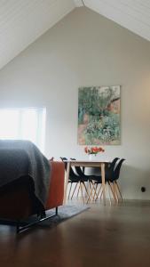 a bedroom with a table and chairs and a painting at Rural Cottage With Views Over Herrljunga in Ljung