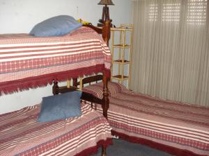 dos camas sentadas una al lado de la otra en un dormitorio en Casa Villa Carlos Paz en Villa Carlos Paz