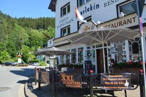 un restaurante con sombrillas frente a un edificio en Aparthotel Harlekin en Willingen