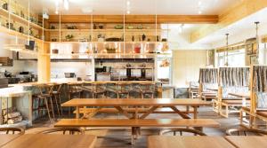 a restaurant with wooden tables and chairs at Hotel Zed Tofino in Tofino