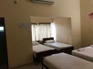 a room with three beds and a window at Wild Wild Holiday in Kataragama