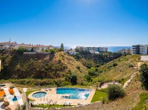 a view of a hill with a swimming pool and the ocean at The Horizon - Luxury 3-Bedroom with Private Plunge Pool and Terrace, South Residences, Higueron Resort, Fuengirola in Fuengirola