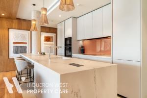 a kitchen with white cabinets and a large island at The Horizon - Luxury 3-Bedroom with Private Plunge Pool and Terrace, South Residences, Higueron Resort, Fuengirola in Fuengirola