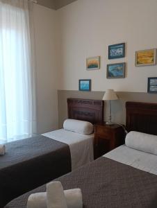 a hotel room with two beds and a window at B&B Liberty in Andria