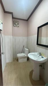 a bathroom with a sink and a toilet and a mirror at khounxub view hotel in Ban Pho Touane