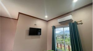 a room with a television and a window at khounxub view hotel in Ban Pho Touane