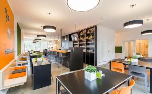um restaurante com mesas e cadeiras e um bar em moveINN em Nordhorn