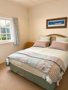 a bedroom with a large bed and a window at Farm Stay | Near Airport & Mystery Creek in Tamahere