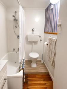 a bathroom with a toilet and a tub and a sink at Farm Stay | Near Airport & Mystery Creek in Tamahere