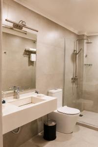 a bathroom with a sink and a toilet and a shower at Cosmopolitan Hotel in Shymkent +35 photos