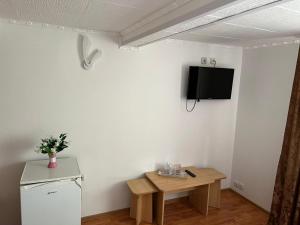 a room with a table and a tv on a wall at Paradis in Buşteni +15 photos