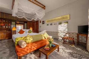a living room with a bed and a couch at Hoi An Chic - Green Retreat in Hoi An