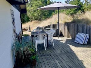 a patio with a table and chairs and an umbrella at Holiday Home On A Huge Nature Plot in Skagen
