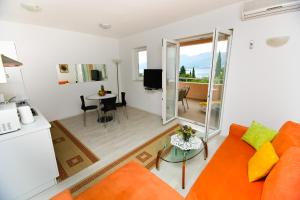 salon z pomarańczową kanapą i stołem w obiekcie Apartments Villa Ana 1 w mieście Cavtat