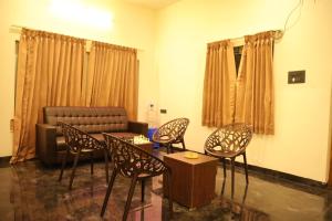 a living room with chairs and a couch at Lumiere Point Yercaud in Yercaud