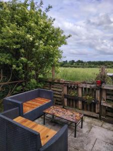 a patio with a blue couch and a table at Namaste Gîte in Plounevez-Quintin