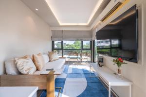 a living room with a couch and a table at Bayphere Residence Private Beach With Fitness and Pool in Na Jomtien