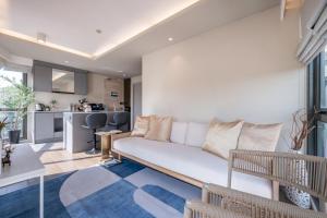 a living room with a couch and a kitchen at Bayphere Residence Private Beach With Fitness and Pool in Na Jomtien