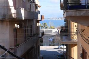 an alley with a view of the ocean from between buildings at Chic Apartment Le Monde in Castellammare del Golfo