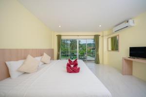 a room with a white bed with a red bow on it at Nan's Aonang in Ao Nang 