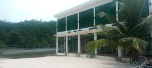 a building with a palm tree in front of it at water fall resort soksan in Phumĭ Kaôh Rŏng