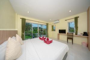 a bedroom with a large white bed with red chairs at Nan's Aonang in Ao Nang 