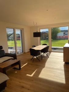 a living room with a table and chairs and a large window at Schoberblick in Thalgau