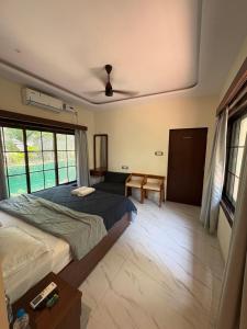 a bedroom with two beds and a table at Seven Seas Beach Resort in Diveagar +13 photos