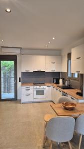 a kitchen with white cabinets and a table and chairs at Milion Living Residences in Parga