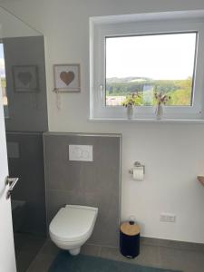 a bathroom with a toilet and a window at Schoberblick in Thalgau