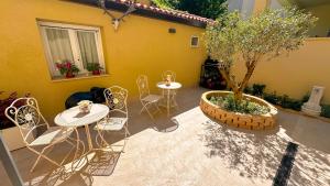 a patio with a table and chairs and a tree at R&B Dimora Teodorico in Ravenna