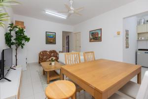 a kitchen and dining room with a wooden table and chairs at Eastern Apartment in Jelutong