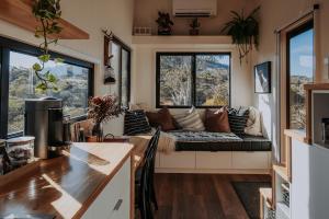 a living room with a couch in front of two windows at Moonbah Escapez in Moonbah